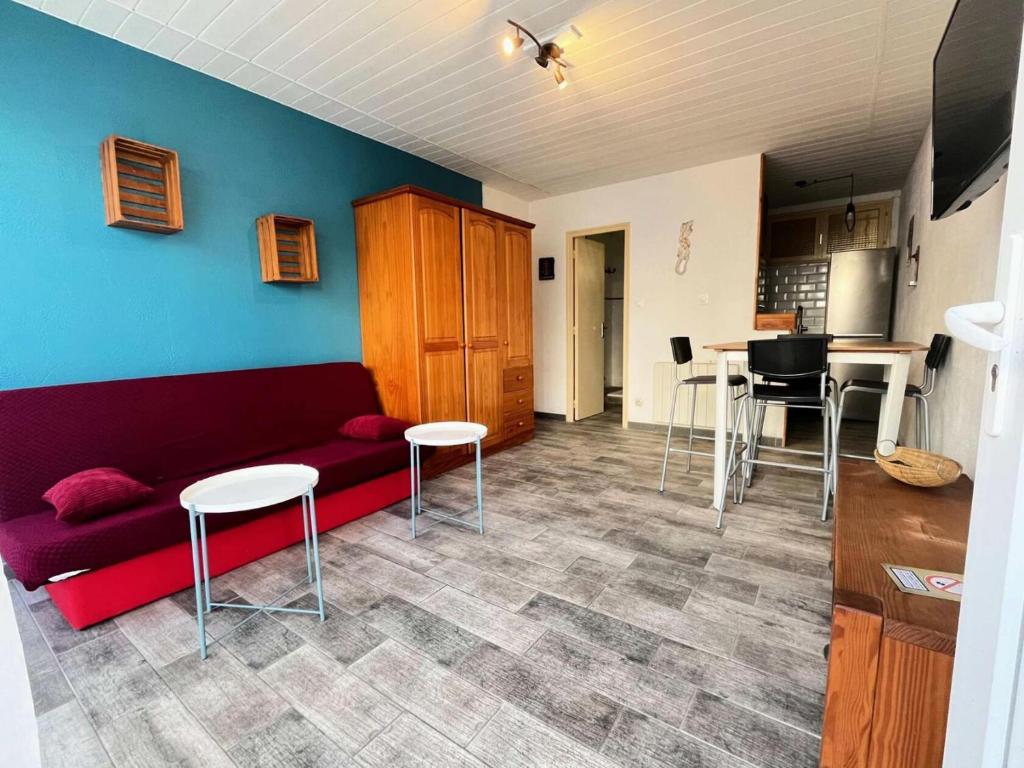 un salon avec un canapé rouge et une cuisine dans l'établissement Résidence Le Clamador - Charmant T2 rénové au Grau du roi MAE-5381, au Grau-du-Roi