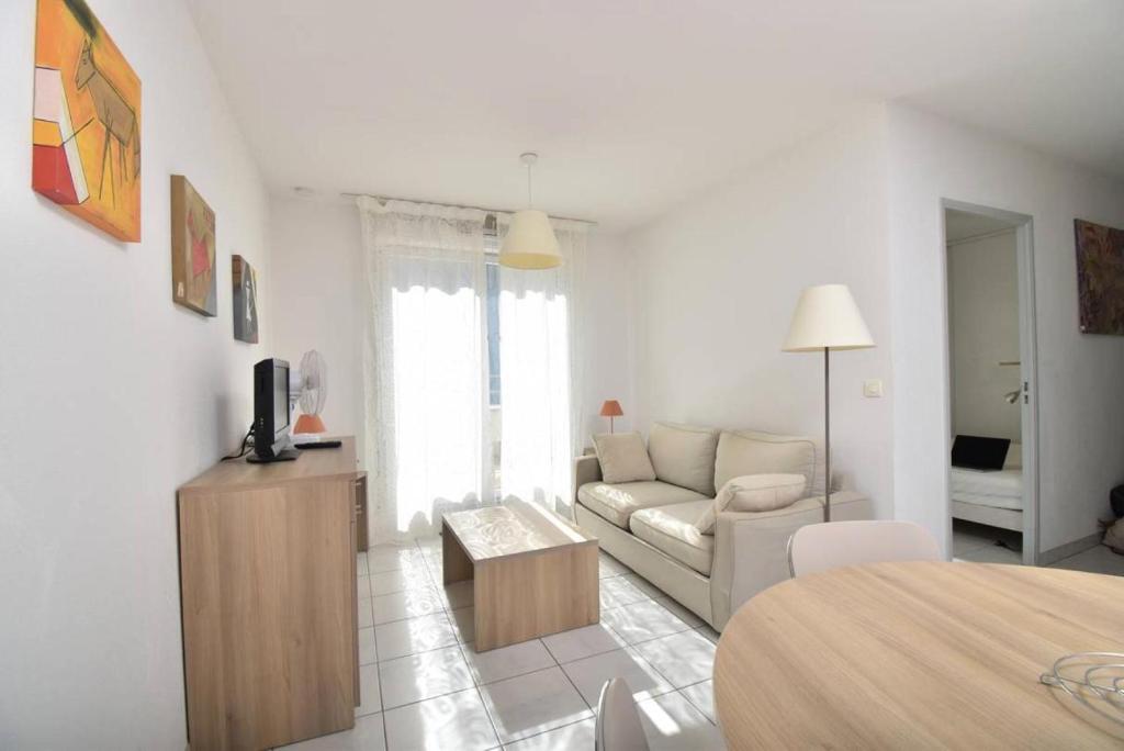 un salon blanc avec un canapé et une table dans l'établissement Résidence Cap Camargue - Un sympathique appartement dans une résidence avec piscine MAE-5391, au Grau-du-Roi