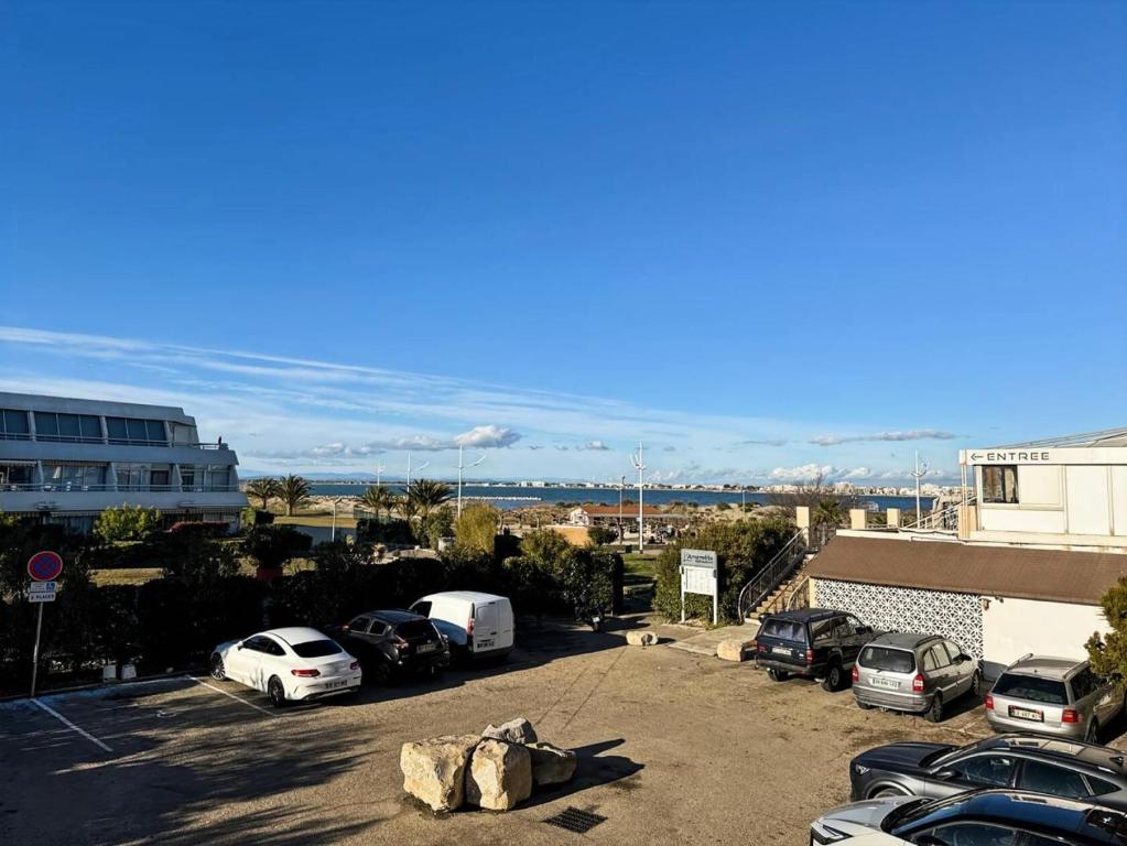 - un parking avec plusieurs voitures dans l'établissement Résidence Le Catamaran - Charmant studio proche plage au grau du roi MAE-5401, au Grau-du-Roi