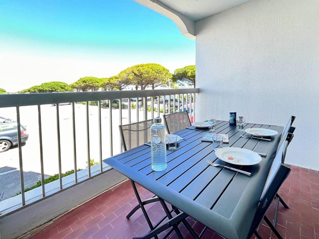 un balcon avec une table bleue et des chaises dans l'établissement Résidence La Croisière - T2 proche plage MAE-5421, au Grau-du-Roi