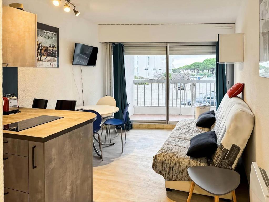 Il comprend un salon avec un lit et une cuisine avec vue. dans l'établissement Résidence La Croisière - Studio cabine 4 couchages MAE-5461, au Grau-du-Roi