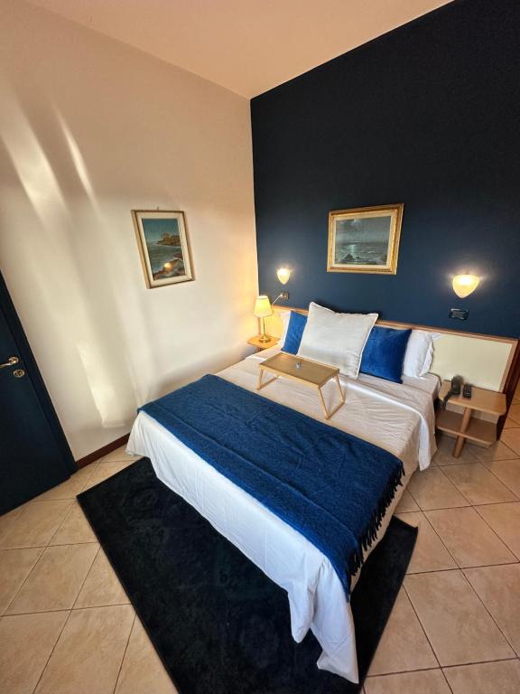 Un dormitorio con una cama grande con una manta azul. en Hotel La Riviera, en Montecatini Terme