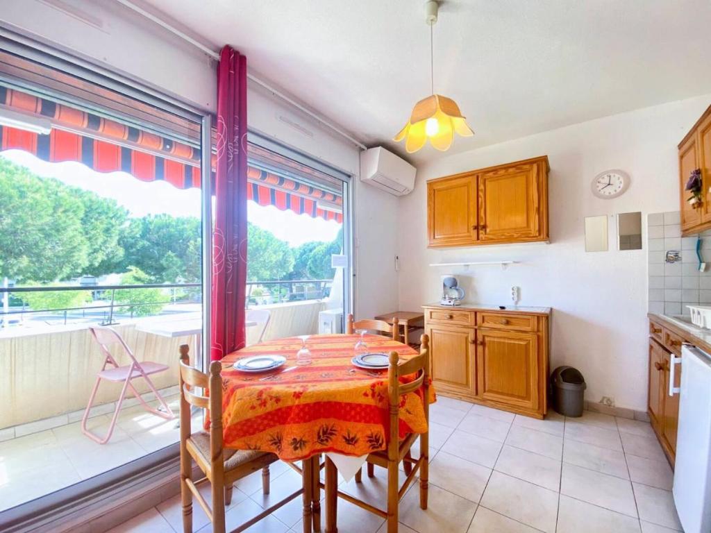 une cuisine avec une table et une grande fenêtre dans l'établissement Résidence Le Méridien - Studio cabine 4 couchages proche plage MAE-7041, au Grau-du-Roi