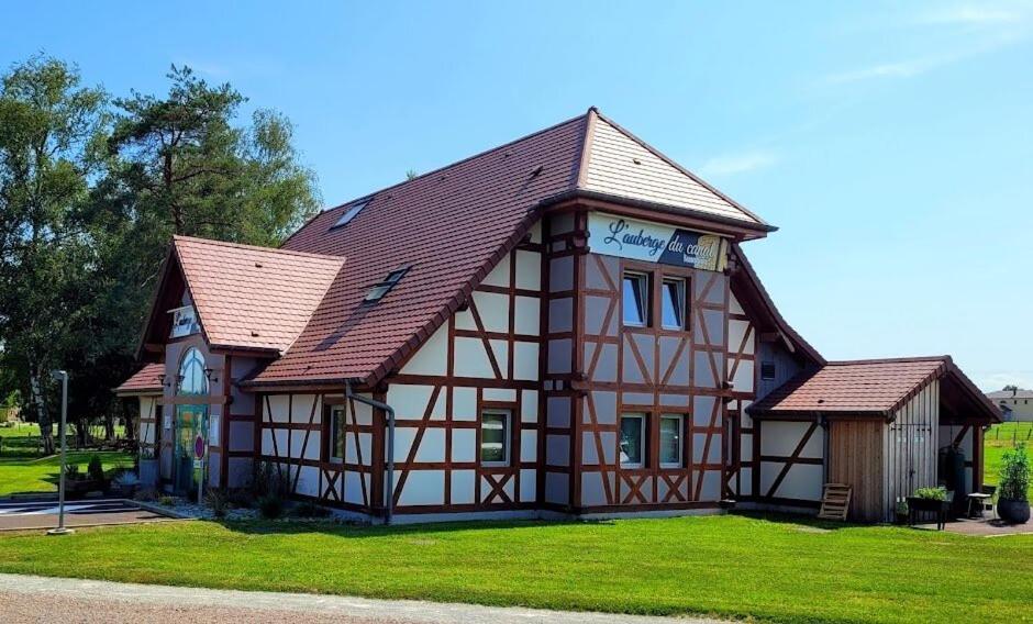 a house with a brown roof and green grass at L'Auberge du canal in Brebotte