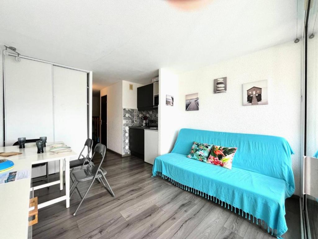 - un salon avec un canapé bleu et un bureau dans l'établissement Résidence Le Lagon Bleu - Studio double cabine avec piscine proche plage MAE-7151, au Grau-du-Roi