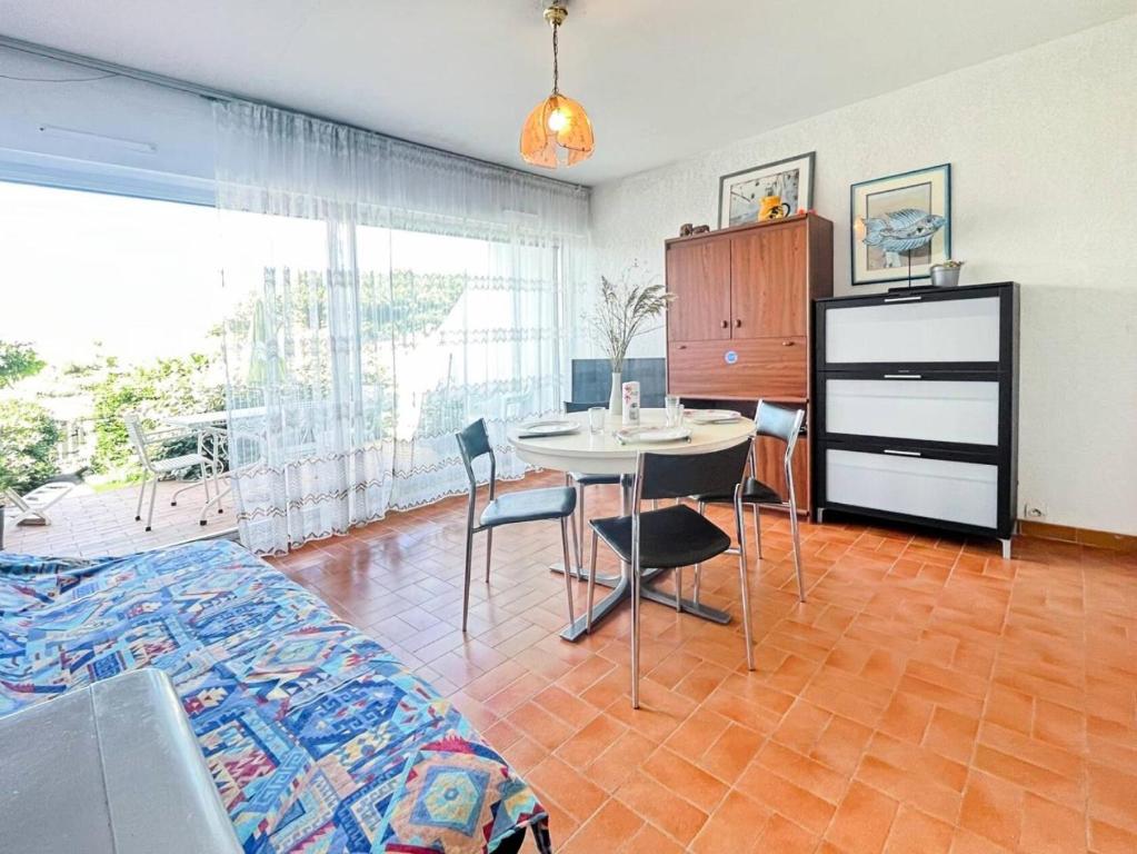 une chambre avec un lit, une table et des chaises dans l'établissement Résidence Les Flamants - Studio en rez de jardin au Grau du roi MAE-7181, au Grau-du-Roi