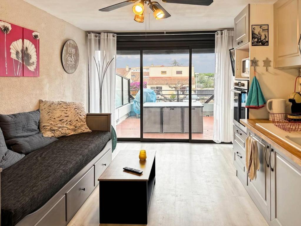 un salon avec un canapé et une table dans l'établissement Résidence Le Lagon Bleu - Studio 4 couchages dans residence avec piscine MAE-7201, au Grau-du-Roi