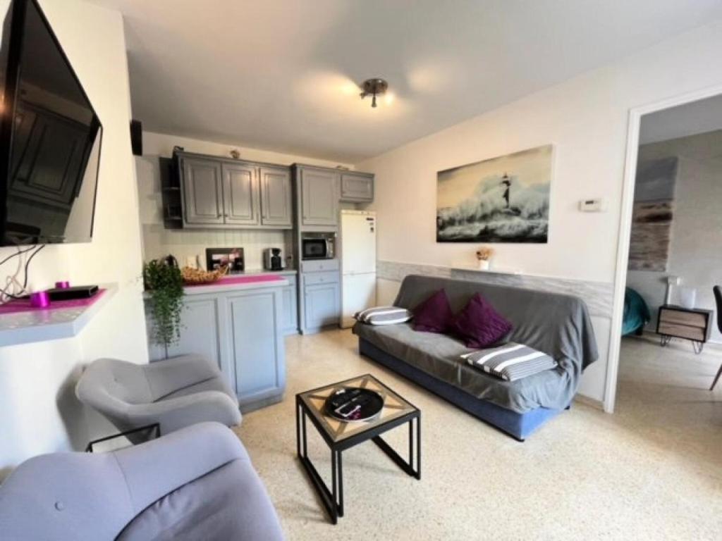 un salon avec un canapé et une table dans l'établissement Résidence Port Royal - Appartement 6 couchages au centre du Grau du roi MAE-9831, au Grau-du-Roi