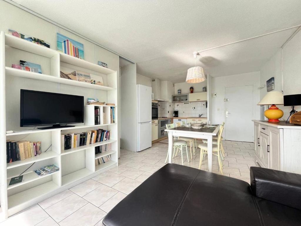 Il comprend un salon avec une télévision et une cuisine avec une table. dans l'établissement Résidence Le Chabian - Appartement 8 couchages au Grau du roi MAE-9851, au Grau-du-Roi