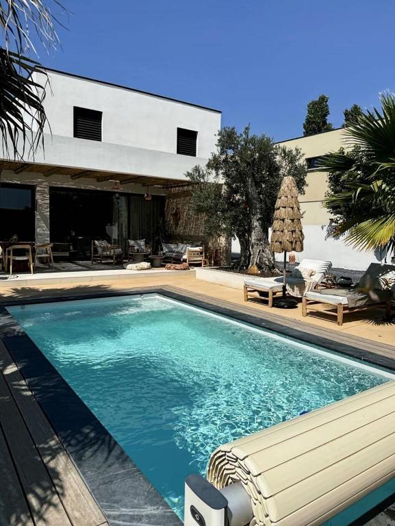 une piscine devant une maison dans l'établissement Résidence Sl565-st Laurent D Aigouze - Superbe villa à Saint laurent d Aigouze MAE-9901, à Saint-Laurent-dʼAigouze