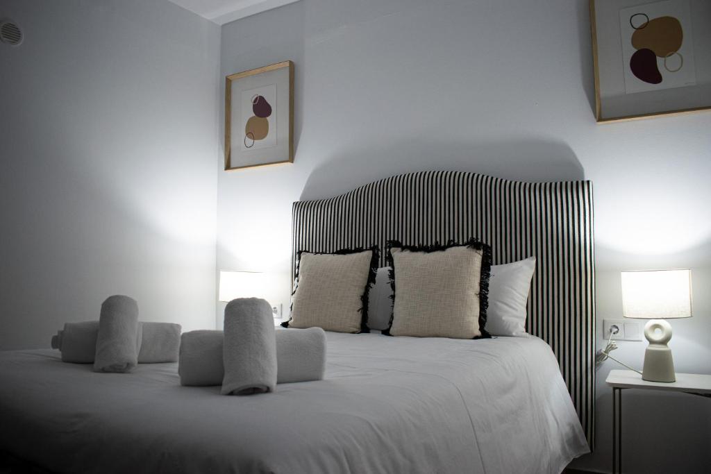 a bedroom with a white bed with white pillows at Apartamento Diocles Centro in Mérida