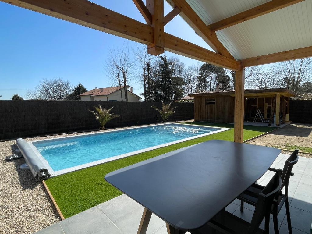 patio ze stołem i basenem w obiekcie La Villa Morey w mieście Casteljaloux