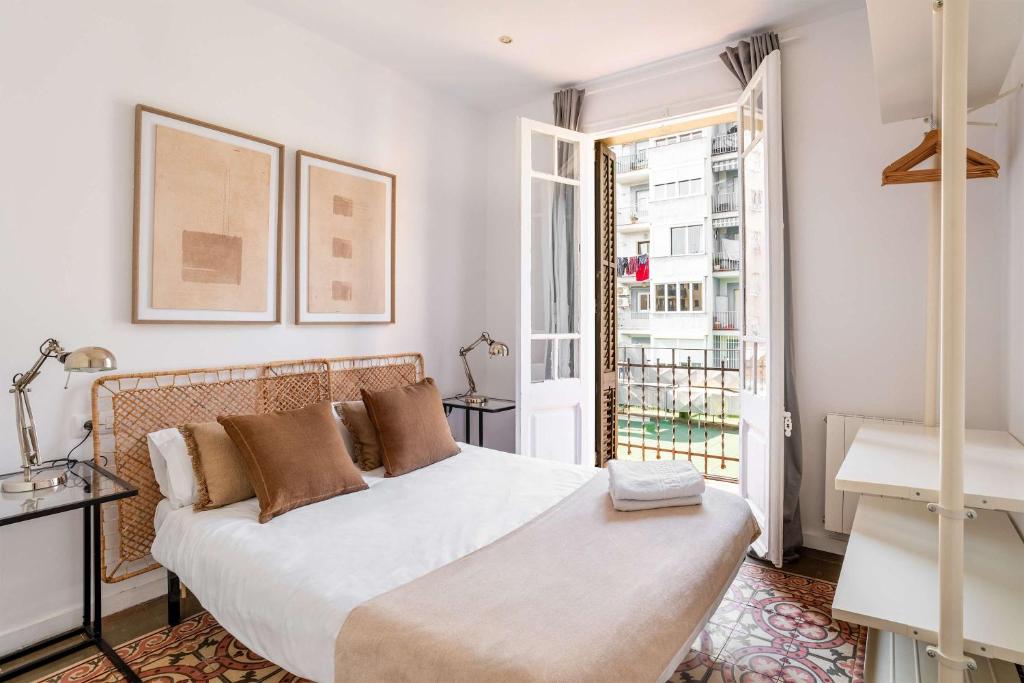 ein Schlafzimmer mit einem großen weißen Bett und einem Fenster in der Unterkunft Sagrada Familia- Emblematic and Charming Catalan Home in Barcelona