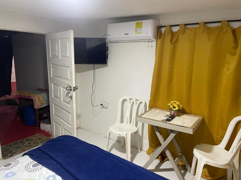a bedroom with a bed and a table and chairs at Habitación independiente cerca al mar. in Puerto Salgar