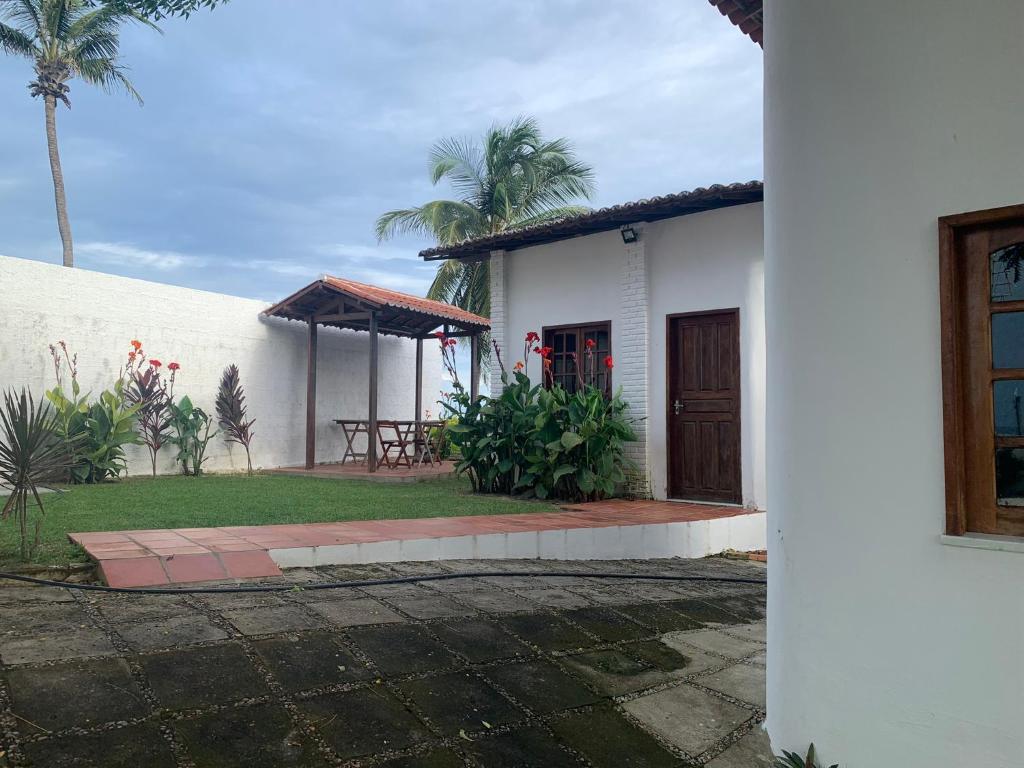 a white house with a porch and a table at Chalés de Morro Branco in Beberibe