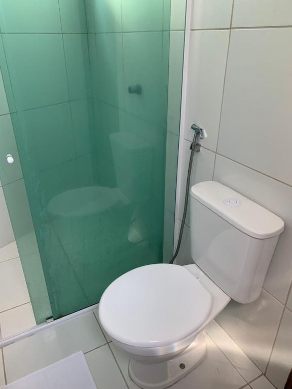 a bathroom with a toilet and a glass shower at Chalés de Morro Branco in Beberibe