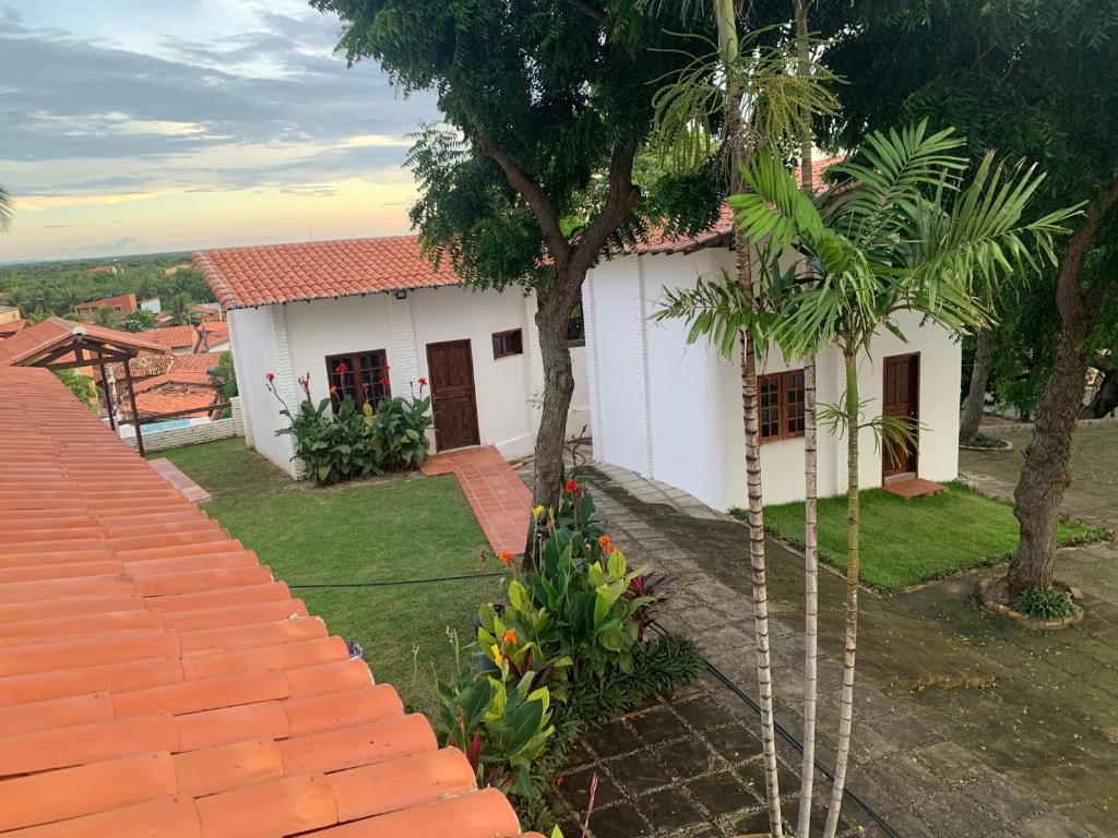 a white house with a palm tree in front of it at Chalés de Morro Branco in Beberibe