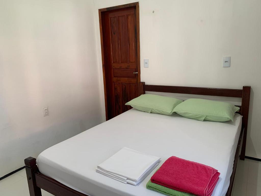 a bedroom with a bed with two towels on it at Chalés de Morro Branco in Beberibe