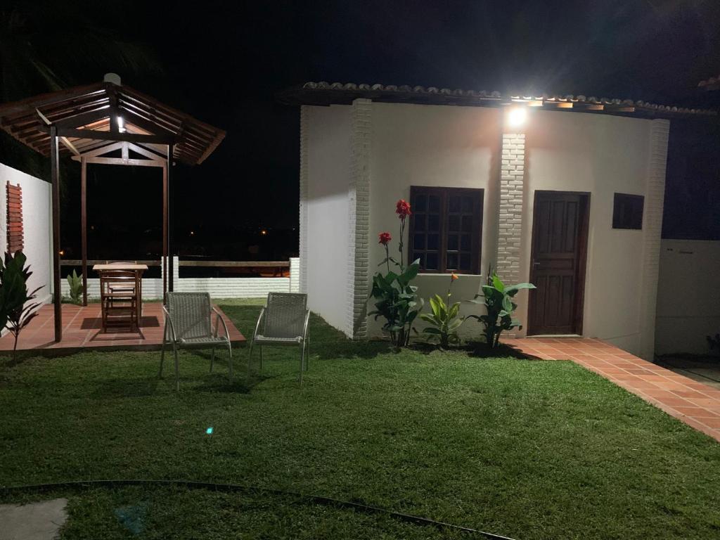 a backyard at night with a light on the side of a house at Chalés de Morro Branco in Beberibe