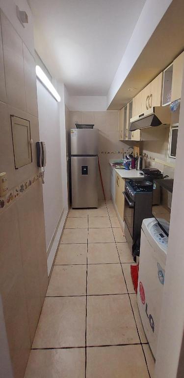 una piccola cucina con frigorifero e pavimento piastrellato di Habitaciones en Miraflores - Departamento compartido Maka's Home a Lima