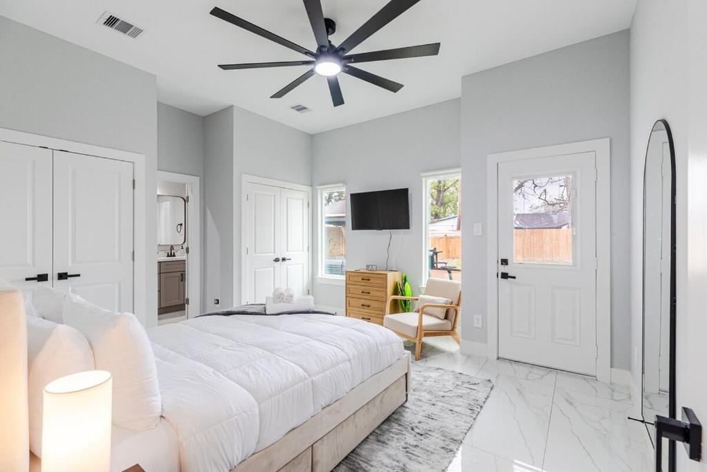 a white bedroom with a large bed and a ceiling fan at 10 Mins from NRG 3BR 3BA in Houston