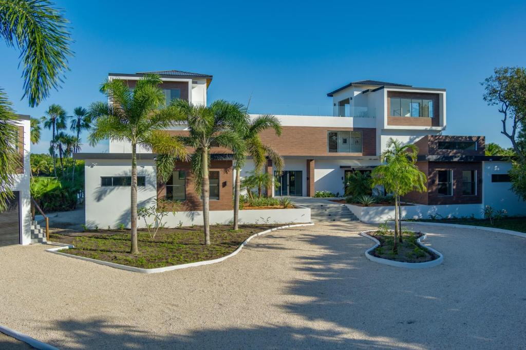a house with palm trees in front of a driveway at Beyond the Blue at Naia Resort in Seine Bight Village