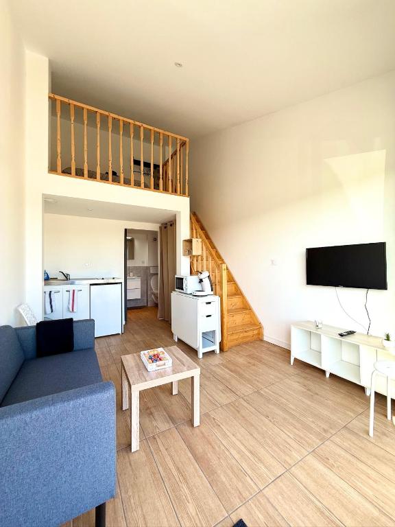 a living room with a couch and a tv at Studio Cosy - Proche MEETT 300m in Cornebarrieu