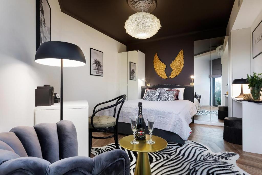 Schlafzimmer mit einem Bett und einem Tisch mit einer Flasche Champagner in der Unterkunft Apartament Art w hotelu Seaside in Kołobrzeg