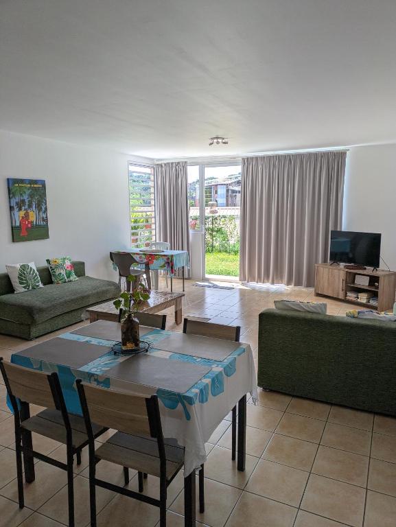 a living room with a table and a couch at N'JOK Papeete in Papeete