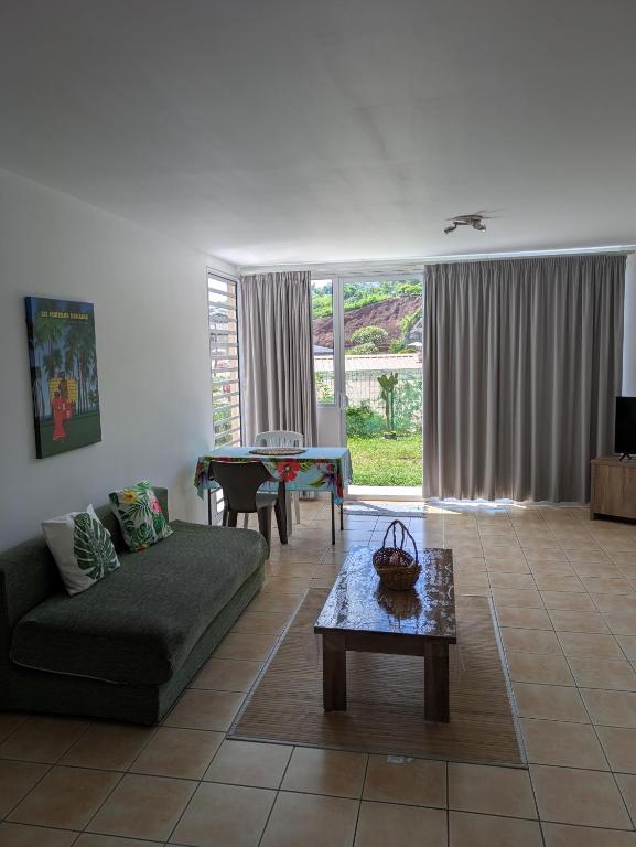 a living room with a couch and a table at N'JOK Papeete in Papeete