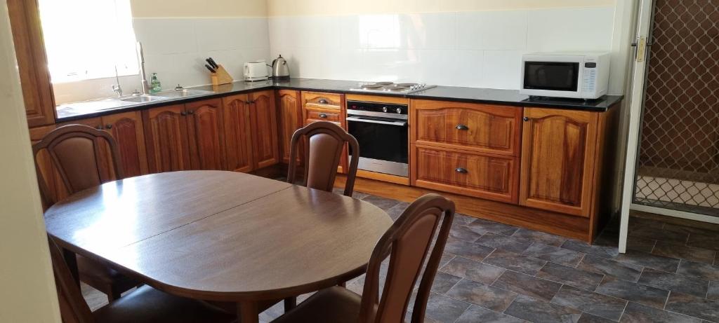 a kitchen with a wooden table and a microwave at River Cottage at Mannum in Mannum