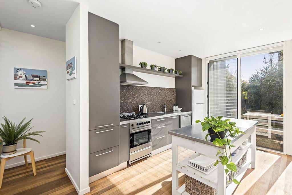 a kitchen with stainless steel appliances and a large window at Perfect Family Getaway in Point Lonsdale