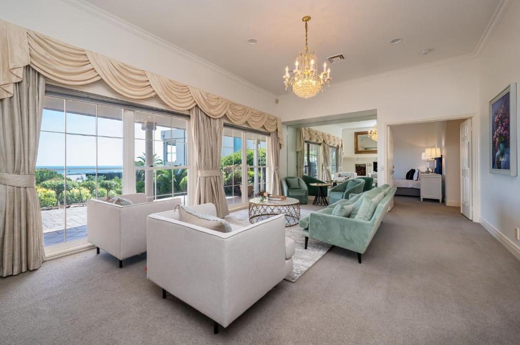 een woonkamer met witte meubels en een groot raam bij Pelican Views in Mount Eliza