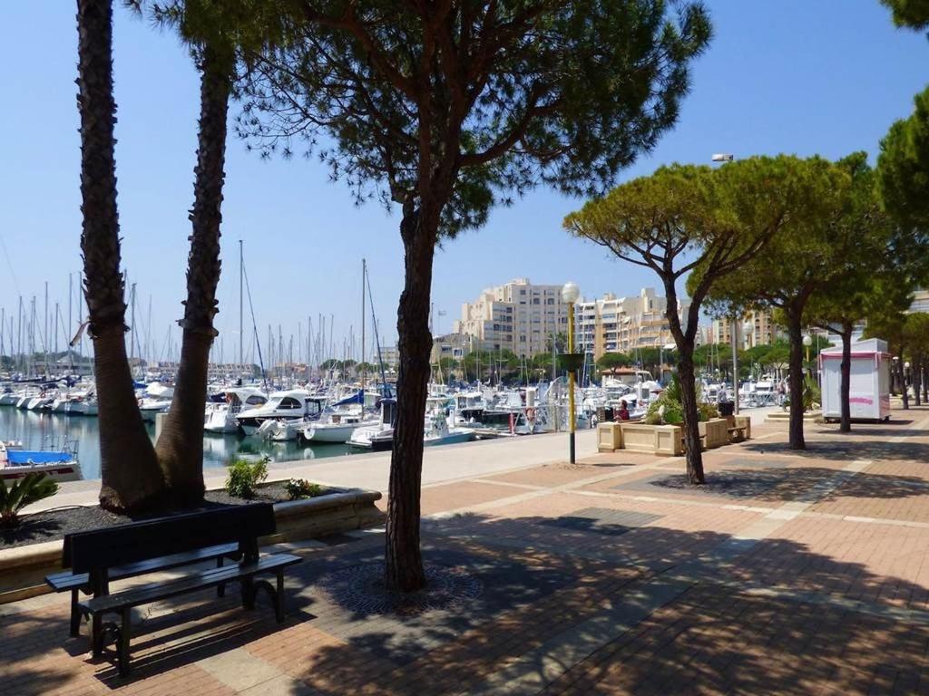 un parc avec des arbres et un banc à côté d'un port de plaisance dans l'établissement Carnon plage Agréable F2 loggia vue port parking, à Carnon-Plage