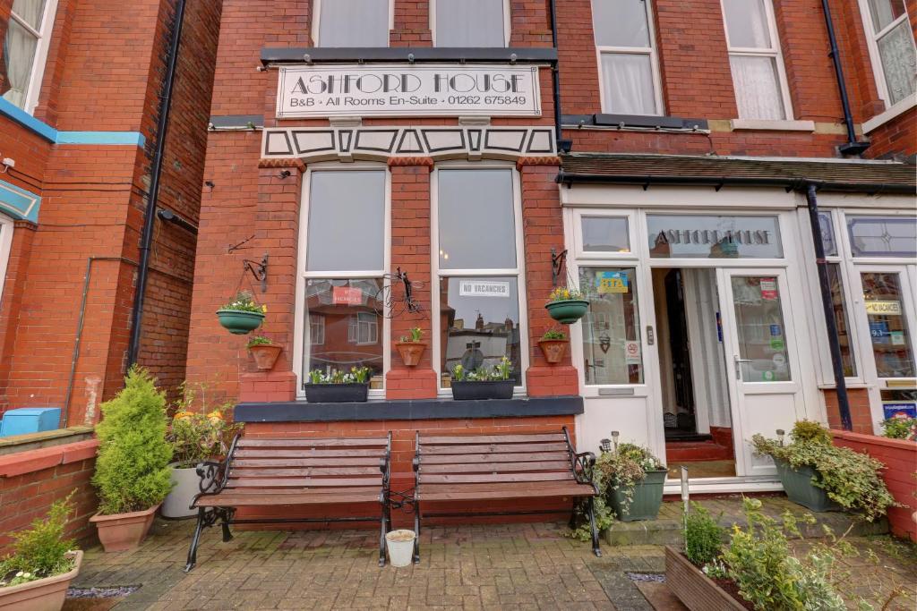 un banco sentado frente a un edificio en Ashford House Guest House, en Bridlington