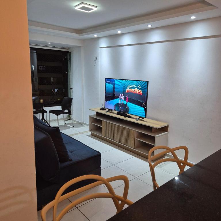 a living room with a flat screen tv on a entertainment center at Apartamento em Recife in Recife