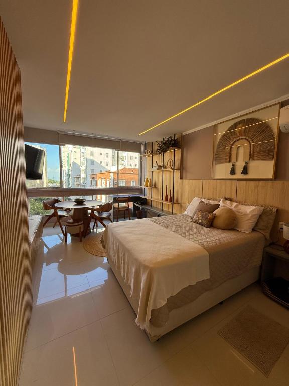 a bedroom with a large bed and a dining room at Studio luxo em Santos vista ao mar in Santos
