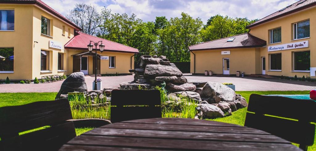 un bâtiment avec une table et des rochers dans une cour dans l'établissement Hotel Twins, à Varsovie