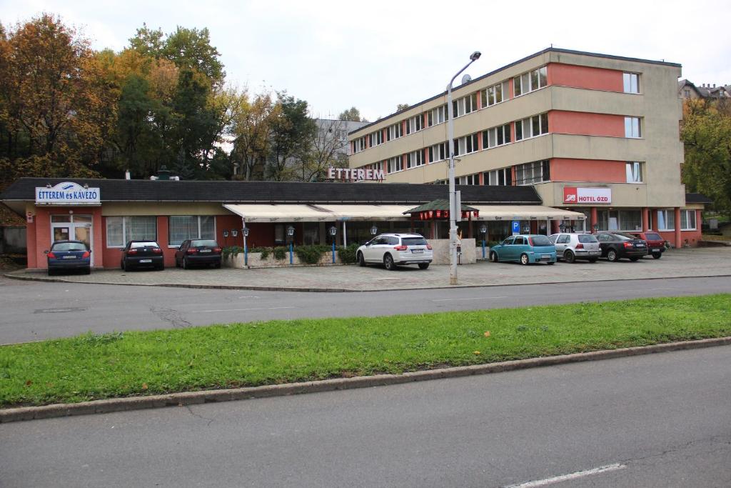 een straat met auto's geparkeerd voor een gebouw bij Hotel Ózd in Ózd