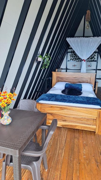 Ciudad BolívarGlamping Arcoiris的一间带床和桌子的小卧室