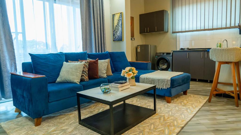 a living room with a blue couch and a table at Serene Abodes MB7 in Kampala