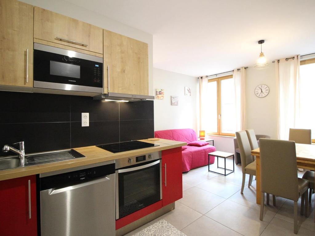 une cuisine et un salon avec un canapé dans l'établissement F2 bis au Mont-Dore, 200m du centre et Thermes, parking privé, animaux acceptés, 6 couchages - FR-1-415-69, à Le Mont-Dore