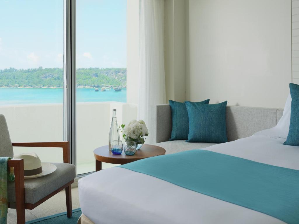 a hotel room with a bed and a view of the water at ANA InterContinental Manza Beach Resort by IHG in Onna