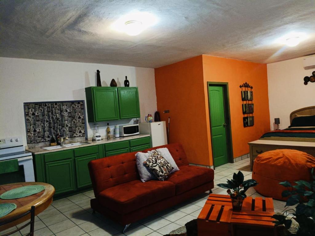 un soggiorno con divano e una cucina con armadi verdi di loft rosy a Puerto Peñasco