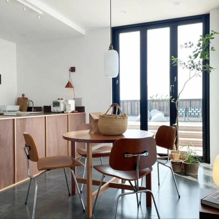 a kitchen with a wooden table and chairs in a room at Deokin Mansion in Jeju