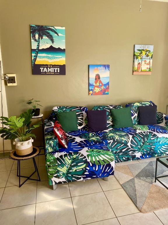 a living room with a couch with colorful pillows at Heiata Lodge Papeete in Papeete