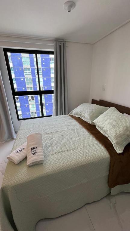 a bedroom with a large bed with two towels on it at Move 517 in João Pessoa