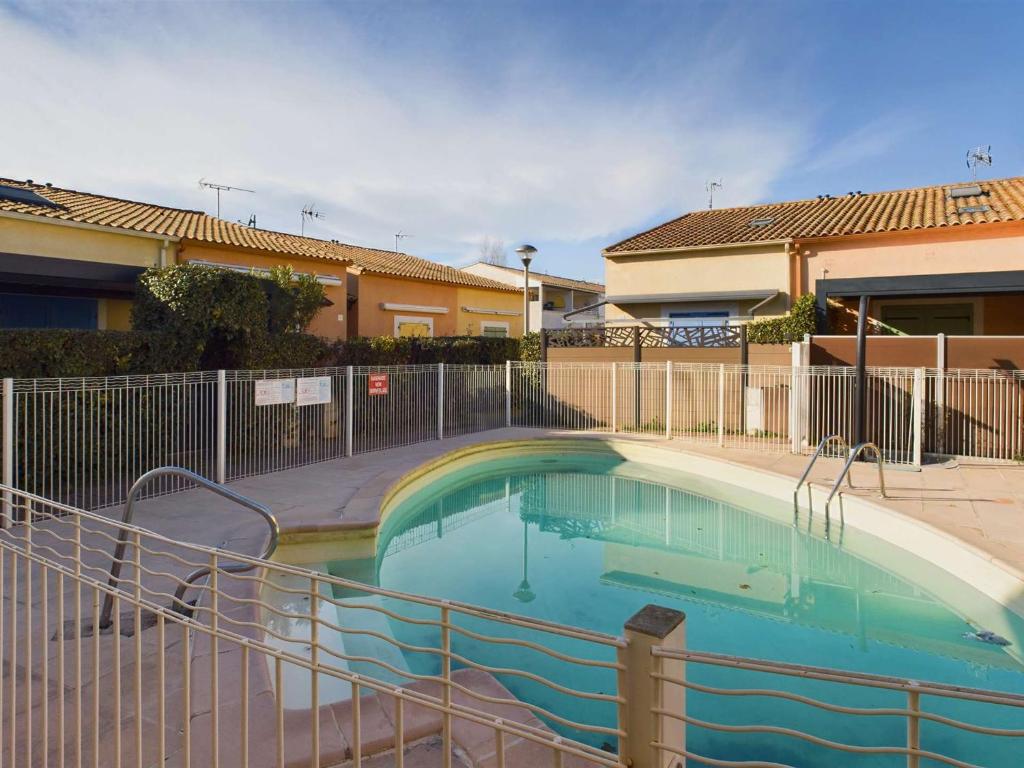 une piscine dans une cour clôturée dans l'établissement Appartement 2 Pièces RDC avec Terrasse et Parking dans Résidence Sécurisée avec Piscine - FR-1-326-846, à Marseillan