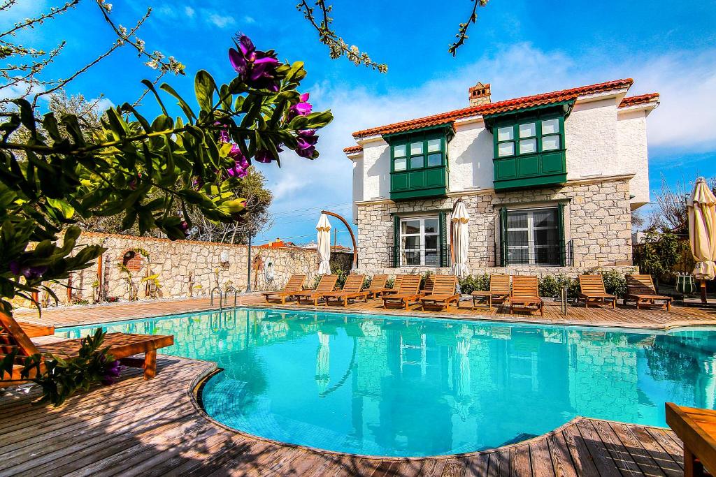 a villa with a swimming pool in front of a house at Alacati Boreas Hotel in Alaçatı