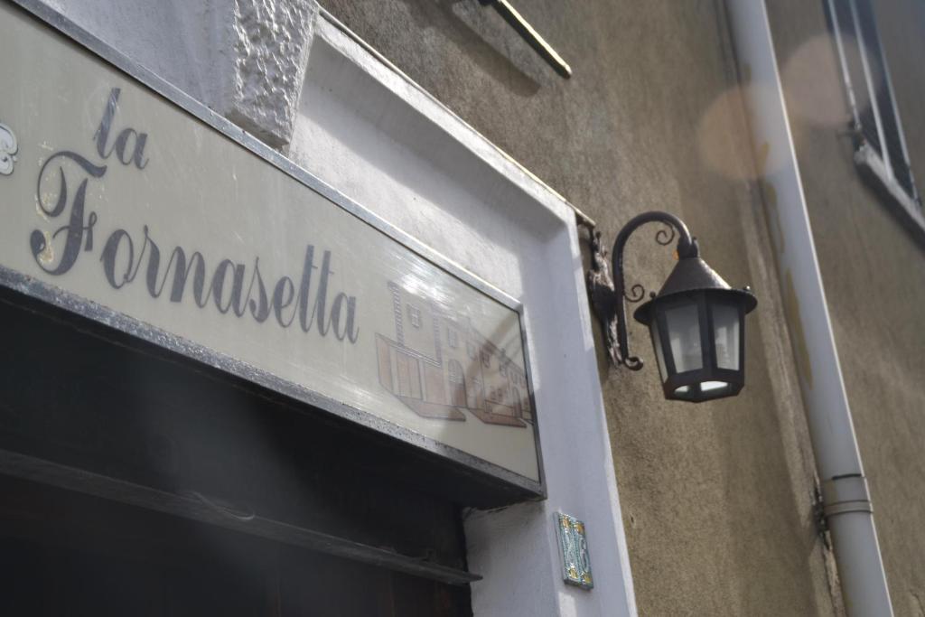 una señal de la calle en el lateral de un edificio con una lámpara en La Fornasetta, en Milán